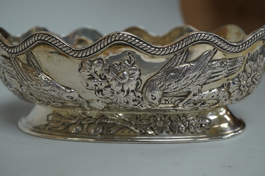 A late Victorian embossed silver oval bowl, decorated with birds, fruit and foliage, Charles Stuart Harris, London, 1889, length 14.3cm, 5.6oz.